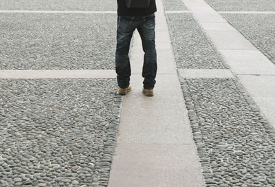 Low section of man walking on road