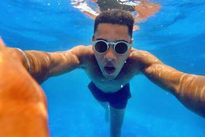 Portrait of young man swimming in pool