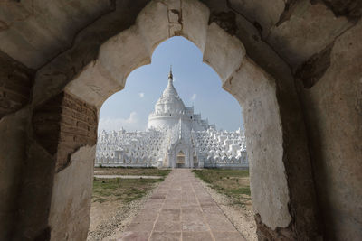 Low angle view of temple seen through arch against sky