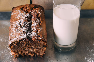 High angle view of chocolate cake with milk glass in baking tray