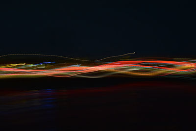 Illuminated light trails over black background