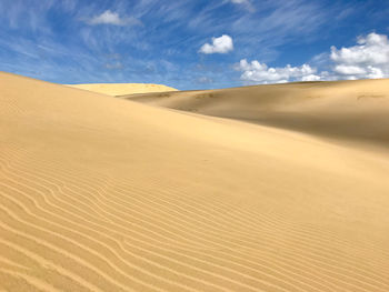 Sand dunes in desert against sky