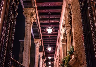 Low angle view of illuminated chandelier hanging at night