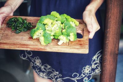 Midsection of person holding vegetables