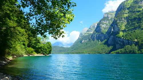 Scenic view of lake by mountains against sky