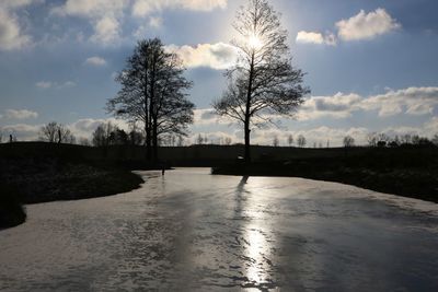 Scenic view of river against cloudy sky