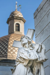 Low angle view of statue against building against sky