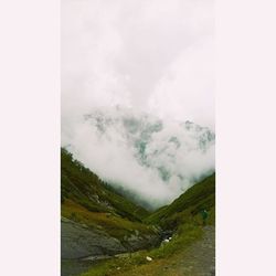 Scenic view of mountains against cloudy sky