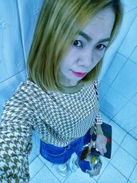 High angle portrait of woman on tiled floor