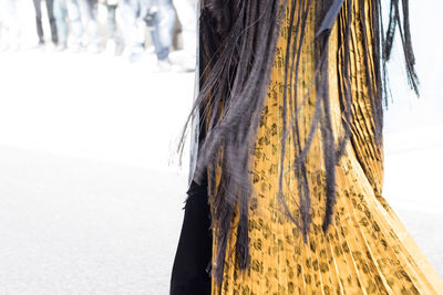 Close-up of woman standing by tree trunk