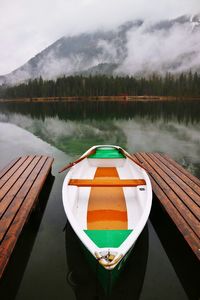 Boat moored on lake against sky