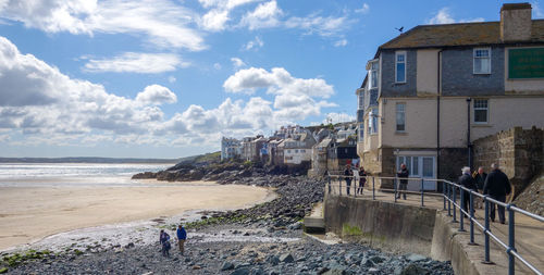 People on beach by sea against sky