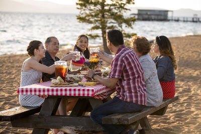 A family enjoys a beach bbq on the shoreline of lake tahoe, nv