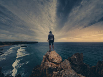 Rear view of man looking at sea against sky