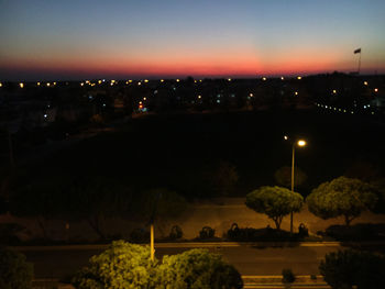 Illuminated city against sky at night