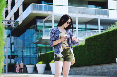 Young happy business woman relaxing in city, outdoor cafe. drinking coffee. using phone. summer