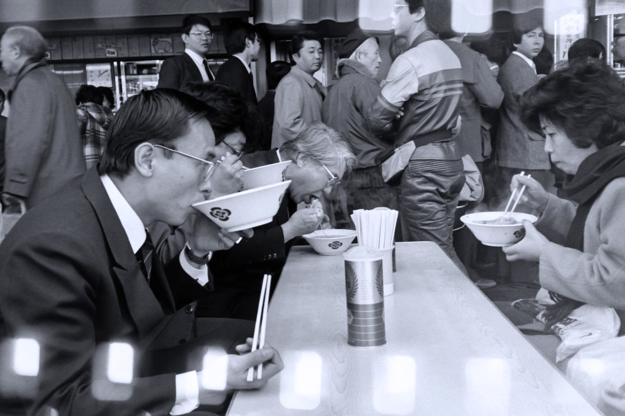 group of people, men, women, real people, food and drink, adult, indoors, table, males, people, group, medium group of people, business, restaurant, crowd, drink, sitting, occupation, standing, glass, uniform, drinking