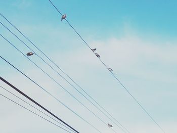 Low angle view of electricity pylon against blue sky