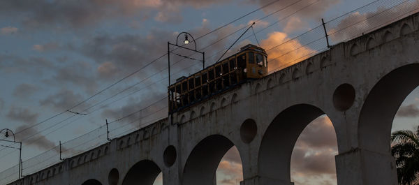 Low angle view of bridge and buildings against sky