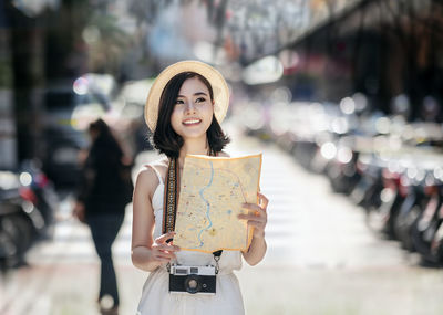 Portrait of a smiling young woman standing on street