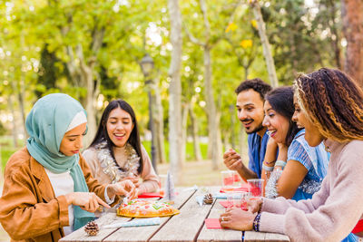 Cheerful friends having food outdoors