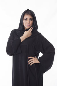 Portrait of young woman standing against white background