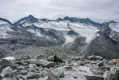 Rear view of person on rocks against mountains