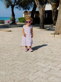 Full length of girl wearing sunglasses on sand