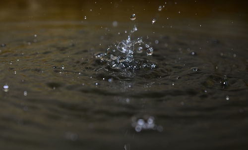 Close-up of drop falling on rippled water