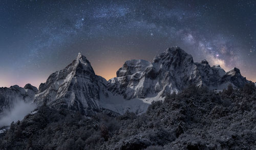 Scenic view of snowcapped mountains against sky at night