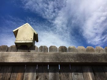 Low angle view of birdhouse on fence