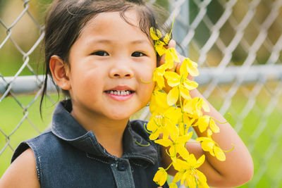 Portrait of happy girl holding flower outdoors