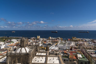 High angle view of town by sea against sky