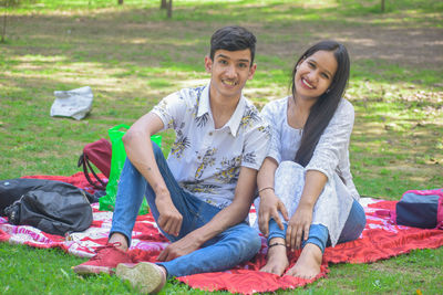 Happy young couple sitting on grass