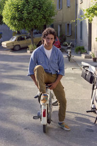 Man riding push scooter on street