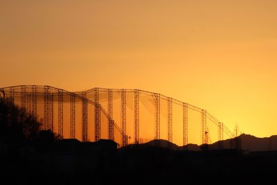 Silhouette built structures against clear sky during sunset