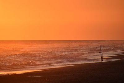 Scenic view of sea against orange sky