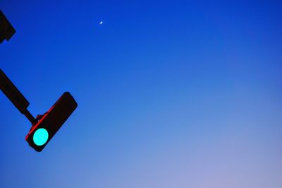 Low angle view of road signal against blue sky