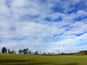 Scenic view of grassy field against cloudy sky