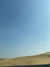 Scenic view of desert against clear blue sky