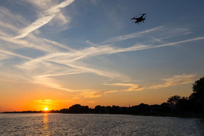 Domestic drone flying over the st. lawrence river in the sunset, lachine, quebec, canada