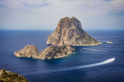 Rock formation in sea against sky