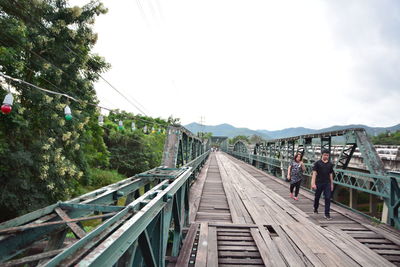 Footbridge over mountain against sky