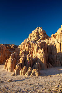 Panoramic view of rocks against clear blue sky