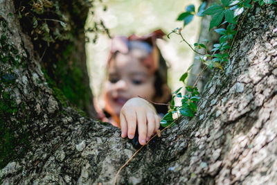 Close-up of hand on tree trunk