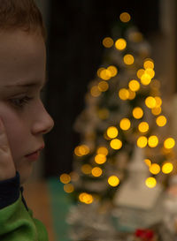 Rear view of boy looking at illuminated christmas tree