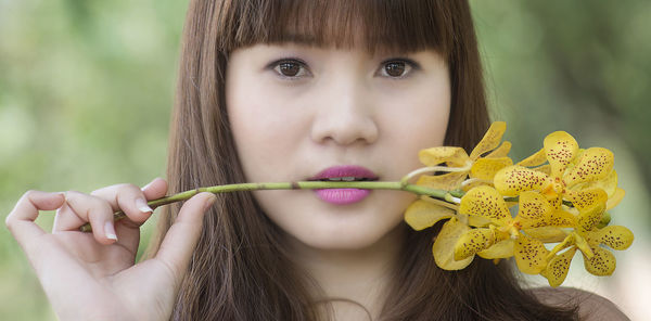 Close-up portrait of a girl holding yellow flower