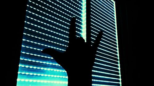 Close-up of silhouette man standing against window