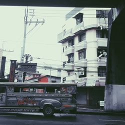 Cars on road in city against sky