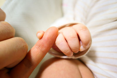 Close-up of baby hand on bed